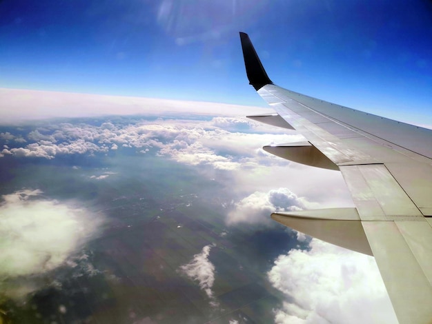 Vista da janela do avião nas nuvens e no céu da asa