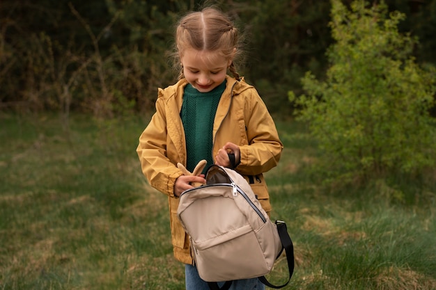 Foto vista da menina com mochila aventurando-se na natureza