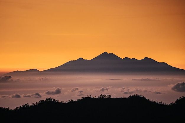 Vista da montanha com neblina ao pôr do sol