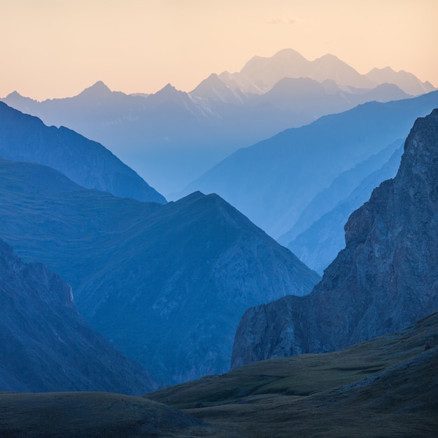 Foto vista da montanha na névoa azul do pôr do sol