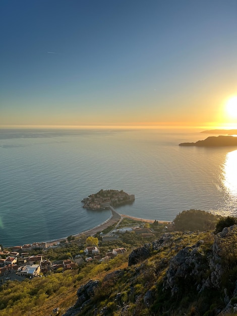 Vista da montanha para a ilha Sveti Stefan ao pôr do sol