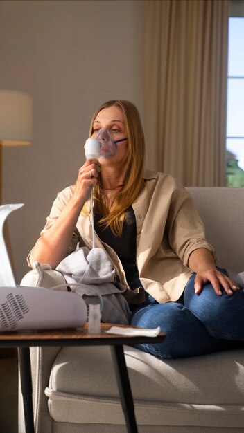 Foto vista da mulher usando nebulizador em casa para problemas de saúde respiratória