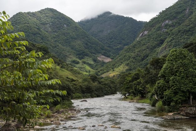 Vista da natureza em Sana, MacaÃƒÂ ©, regiÃ £ o serrana do Rio de Janeiro. Foto do rio com montanhas ao redor da entrada da cidade.