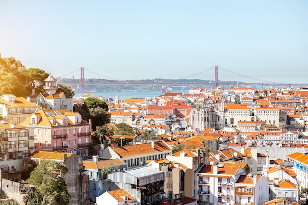 Foto vista da paisagem urbana da cidade de lisboa com a famosa ponte durante o dia ensolarado em portugal