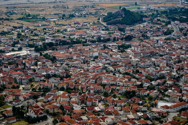 Vista da paisagem urbana de antigos edifícios de telhado vermelho em Kalambaka de rocha de mosteiros de Meteora