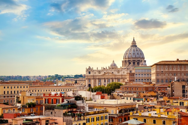 Foto vista da paisagem urbana de roma ao pôr do sol com a catedral de são pedro no vaticano.