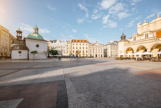 Vista da paisagem urbana na Praça do mercado com belos edifícios antigos e a igreja de Adalberto durante a luz da manhã em Cracóvia, Polônia