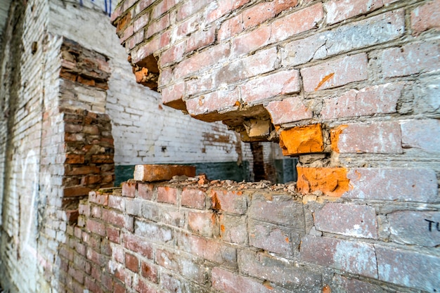 Vista da parede de ruptura na antiga fábrica. Dano abandonado velho da fábrica da ruína que constrói para dentro