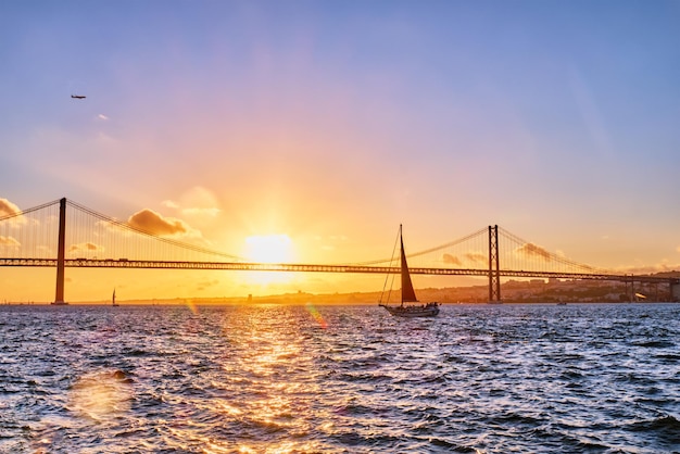 Vista da ponte 25 de abril sobre o rio Tejo no pôr do sol Lisboa Portugal