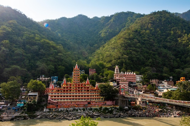 Vista da ponte Lakshman Jhula do aterro do rio Ganges e do Templo Tera Manzil Rishikesh Índia