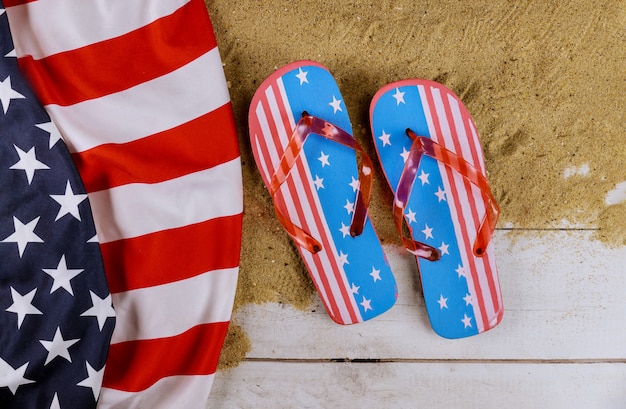 Vista da praia de areia com bandeira americana, férias de temporada de verão chinelos de praia