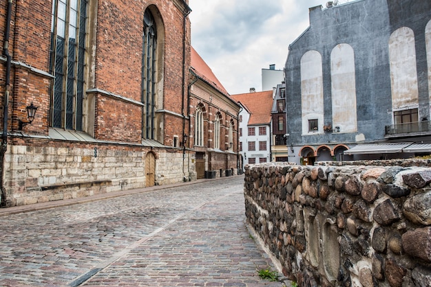 Vista da rua da cidade velha de Riga perto da Igreja Luterana de São João, Letônia