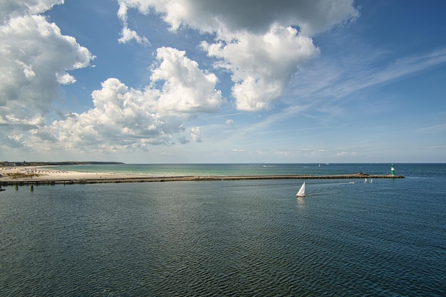 Vista da saída do porto de rostock sobre a praia de warnemunde e o farol