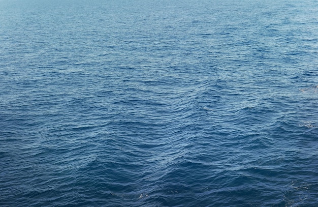 Vista da superfície do oceano azul com fundo do mar ondulado