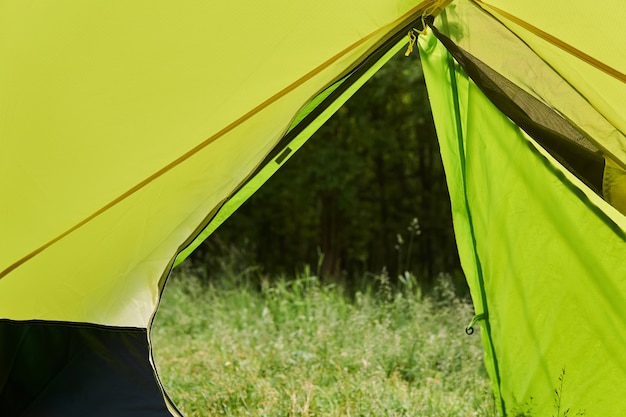 Foto vista da tenda de caminhada para a floresta no verão por meio de uma entrada aberta