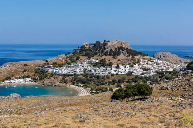 Vista da vila de Lindos e ruínas com Acrópole em uma colina fora da água em Lindos Rhodes Grécia