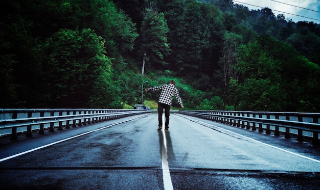 Vista das costas de um homem caminhando em uma ampla paisagem natural