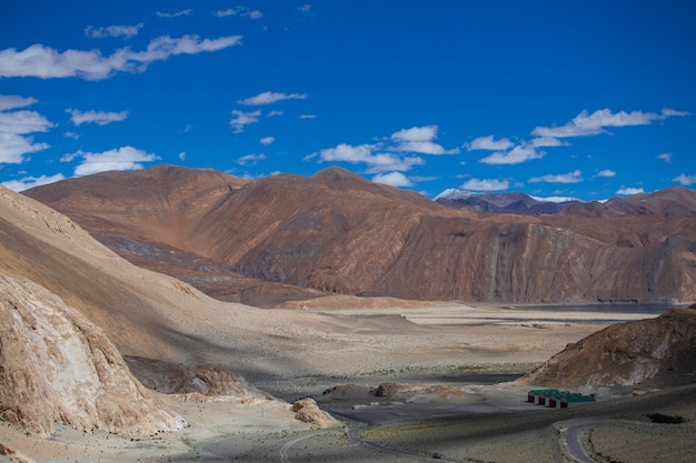 Vista das majestosas montanhas rochosas contra o céu azul e nuvens brancas no himalaia indiano, região de ladakh, índia. natureza e conceito de viagens