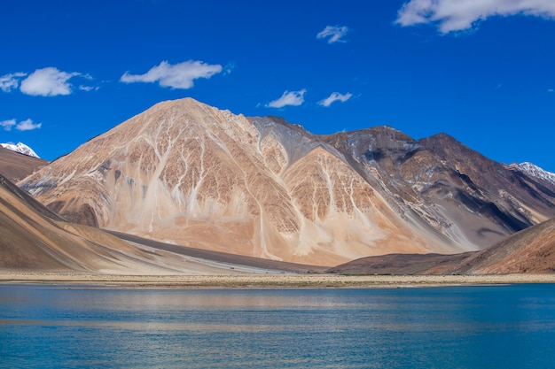 Vista das majestosas montanhas rochosas contra o céu azul e o lago Pangong no Himalaia indiano, região de Ladakh, Jammu e Caxemira, Índia. Natureza e conceito de viagens