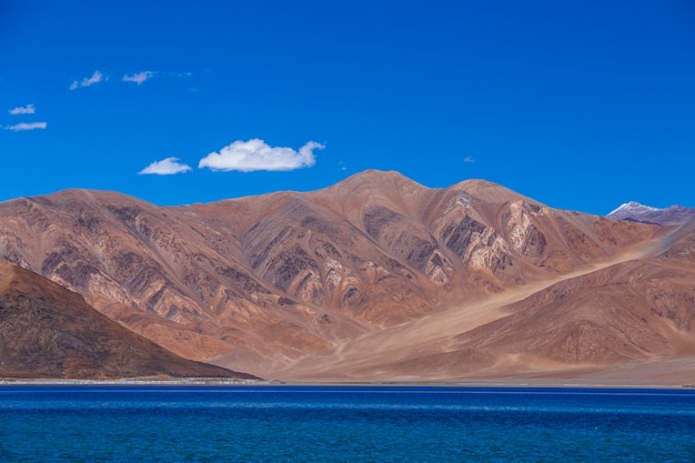 Vista das majestosas montanhas rochosas contra o céu azul e o lago Pangong no Himalaia indiano, região de Ladakh, Jammu e Caxemira, Índia. Natureza e conceito de viagens