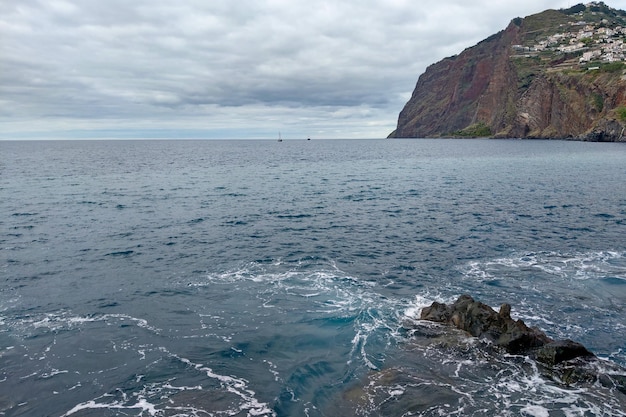 Vista das rochas da Ilha da Madeira e dos barcos no Oceano Atlântico
