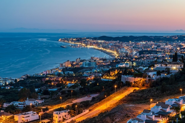 Vista de alto ângulo da cidade iluminada pelo mar contra o céu