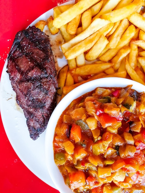 Foto vista de alto ângulo da comida servida por batatas fritas e carne no prato