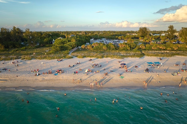 Vista de alto ângulo da praia lotada de nokomis no condado de sarasota, eua muitas pessoas aproveitam as férias nadando na água do oceano e relaxando no sol quente da flórida ao pôr do sol