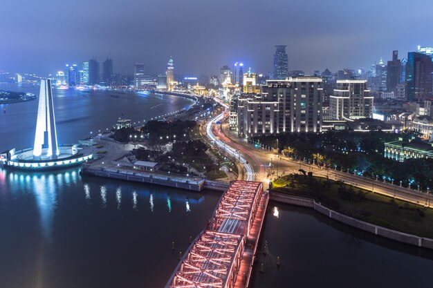 Vista de alto ângulo da rodovia iluminada no meio dos edifícios à noite