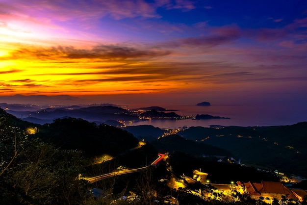 Vista de alto ângulo das montanhas pelo mar contra o céu durante o pôr-do-sol