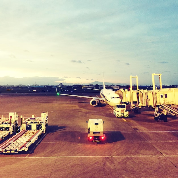 Foto vista de alto ângulo de avião e ponte de embarque de passageiros na pista do aeroporto contra o céu no aeroporto de miyazaki