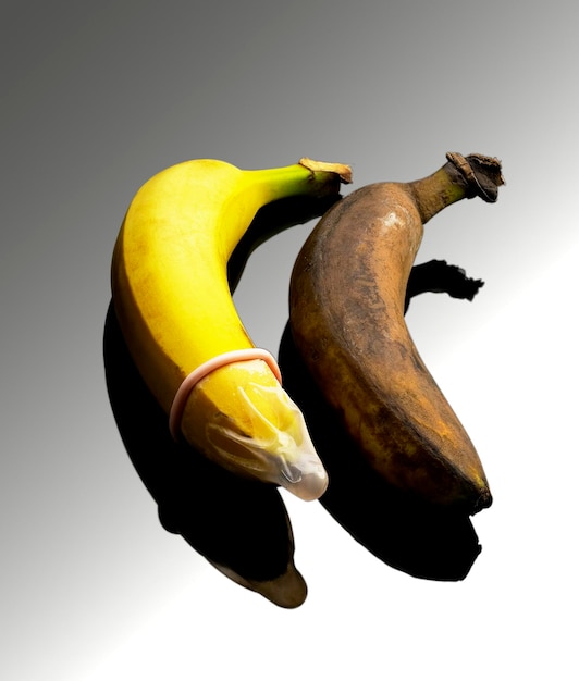 Foto vista de alto ângulo de bananas com preservativo em fundo cinzento