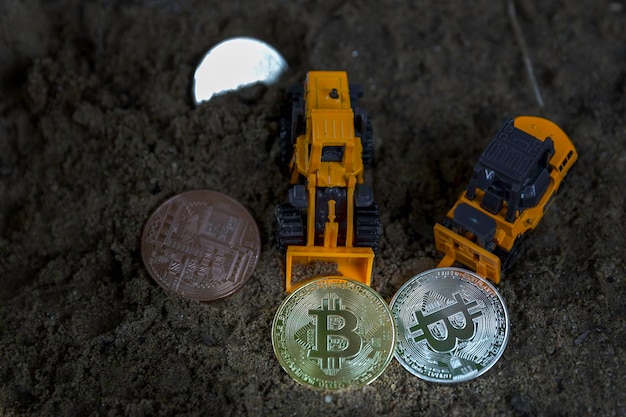 Foto vista de alto ângulo de bitcoins e caminhões de brinquedo na sujeira