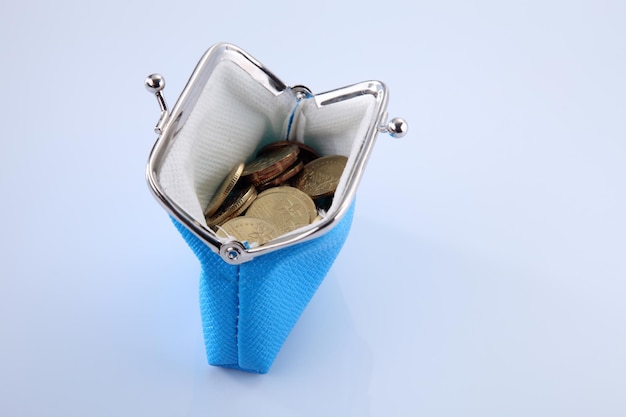Foto vista de alto ângulo de bolsa azul com moedas contra fundo branco