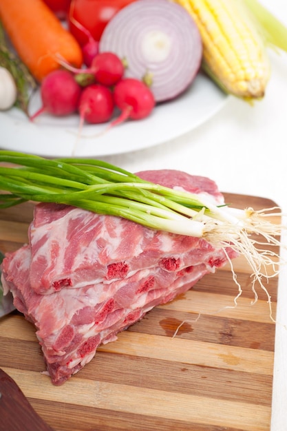 Vista de alto ângulo de carne e legumes na tábua de cortar