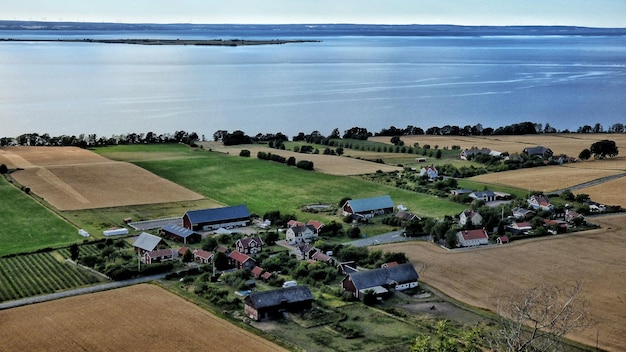 Vista de alto ângulo de casas em campos agrícolas pelo mar