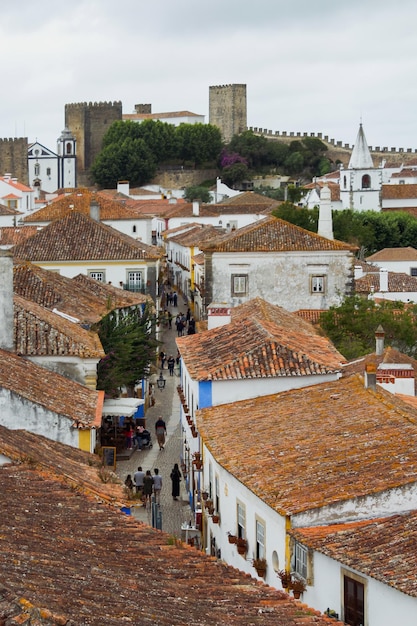 Foto vista de alto ângulo de casas na cidade medieval de obidos com castelo contra o céu