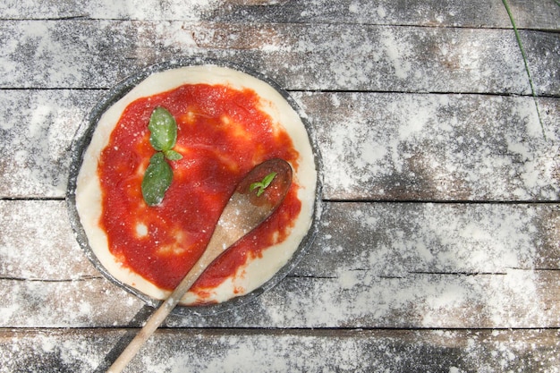 Foto vista de alto ângulo de colher de madeira sobre pizza na mesa