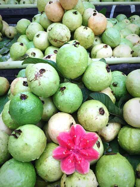 Foto vista de alto ângulo de frutas frescas e molhadas de goiaba em uma barraca de mercado