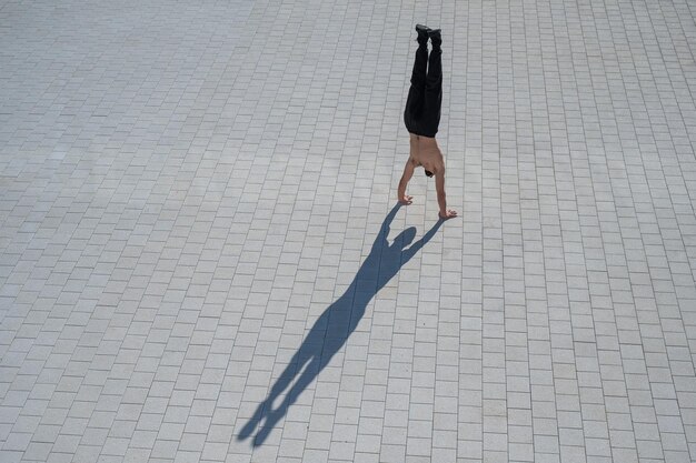 Vista de alto ângulo de homem fazendo handstand na rua