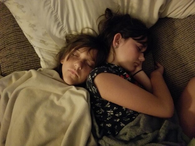 Foto vista de alto ângulo de irmãos dormindo na cama