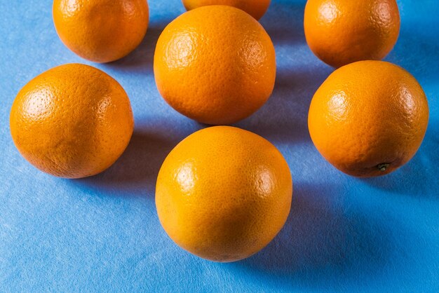 Vista de alto ângulo de laranjas em fundo azul