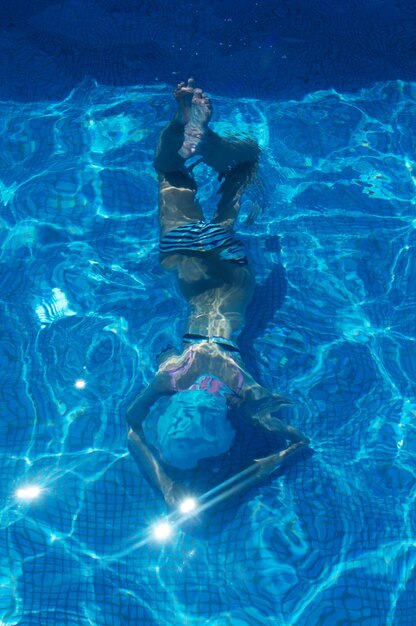 Foto vista de alto ângulo de menina nadando na piscina