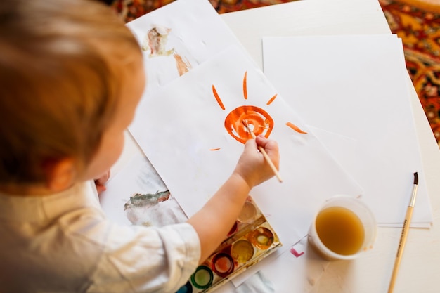 Vista de alto ângulo de menino desenhando em papel em casa