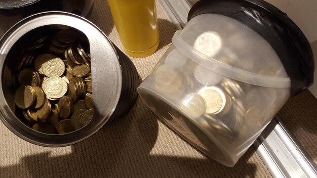 Foto vista de alto ângulo de moedas em recipientes sobre a mesa