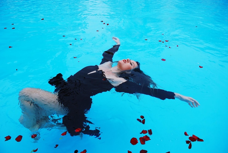 Foto vista de alto ângulo de mulher flutuando na piscina