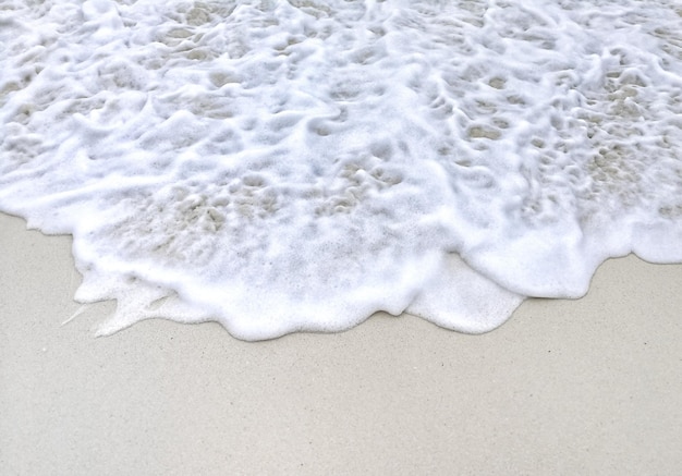 Foto vista de alto ângulo de ondas correndo em direção à costa na praia
