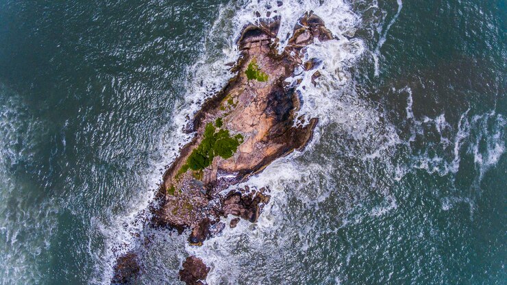 Foto vista de alto ângulo de ondas espalhando em rochas ilha situada em guaruja sao paulo brasil