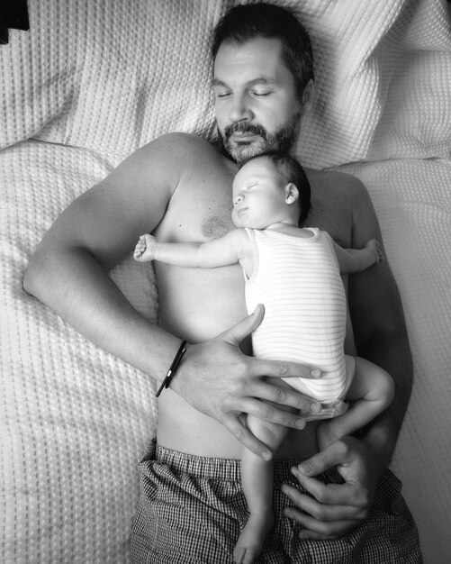 Foto vista de alto ângulo de pai e filho dormindo na cama em casa