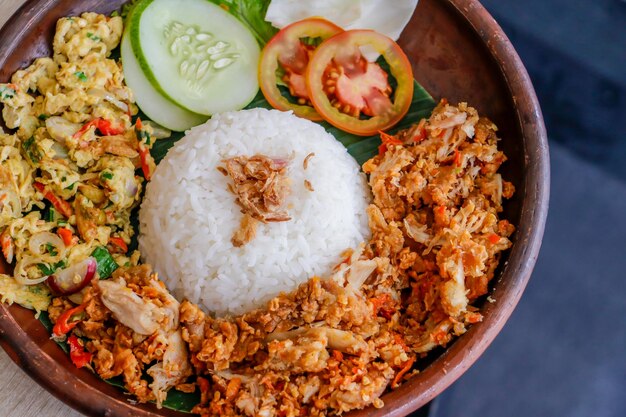 Foto vista de alto ângulo de pecel de frango de arroz uduk em um prato na mesa